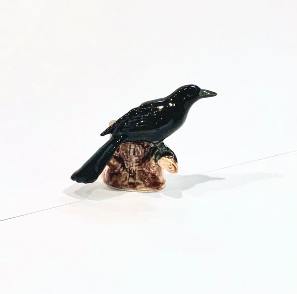 Ceramic Black Crow on a log.