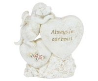 memorial dog sitting on a small heart with flowers and leaning on a big heart. A saying “Always in our heart” is written on the larger heart