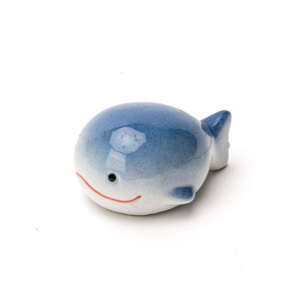 Floating Porcelain Blue Whale with black eyes and red mouth.