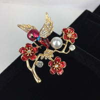 Beautiful brooch - crystal winged bird with red body on red flowers with a pearl on branch