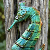 Beautiful  Lone seahorse in greens and ocean tones. Great quality product that is  painted front & back and lacquered to longevity. Each seahorses is a metal wall hanging with hanging points perfect for indoors & covered outdoor areas.  Dimensions: Small 13.5cm x 37cm